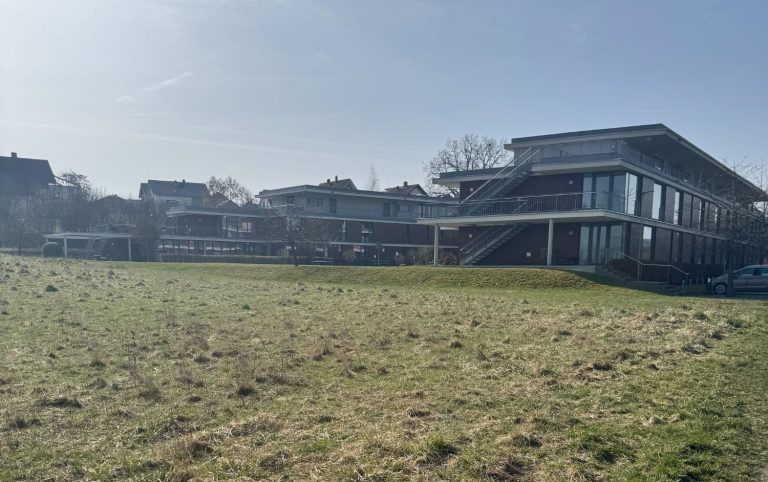 Feld mit Gebäude im Hintergrund